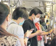  ?? APICHIT JINAKUL ?? Passengers wear masks on the skytrain in Bangkok. Tech firms are developing mobile apps to prevent the spread of the coronaviru­s.