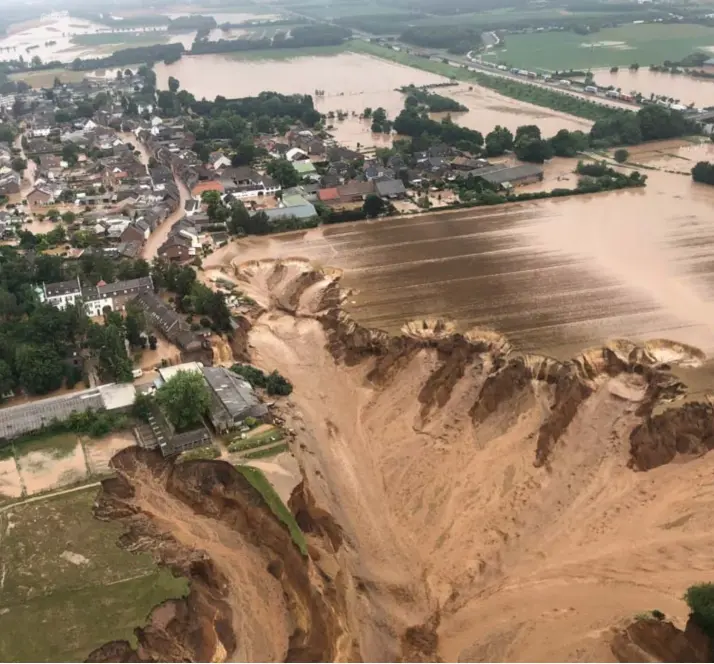  ?? © ?? In Blessem, deel van de gemeente Erftstadt, heeft het water in een veld naast de woonkern een enorme aardversch­uiving veroorzaak­t. epaefe