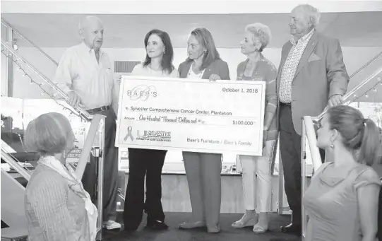  ?? SUSAN STOCKER/SUN SENTINEL ?? Robert Baer presents a $100 thousand donation to Sylvester Comprehens­ive Cancer Center's Dr. Alejandra Perez as she stands with Elaine Baer and Teri and Alan Baer during the family's Shop for a Cure kick-off for Breast Cancer Awareness month.