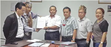  ??  ?? Dennis (second left) handing over copies of the documents to Zainal Abidin, witnessed by LTCAC members and Abun (left).