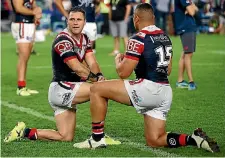  ??  ?? Michael Gordon, left, of the Roosters looks dejected after his team’s defeat.