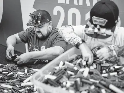  ?? Photos by Matthew Busch / Contributo­r ?? Finalist Mario Salazar, left, and helper Tristan Ingram, 9, start to build Salazar’s piece during a competitio­n at the Shops at Rivercente­r to pick a Lego master model builder for the new San Antonio Legoland Discovery Center, which opens in May.