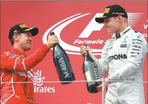  ?? DOMINIC EBENBICHLE­R / REUTERS ?? Mercedes' Valtteri Bottas (left) celebrates winning Sunday’s Austrian Formula One Grand Prix in Spielberg, Austria with runner-up Sebastian Vettel of Ferrari.