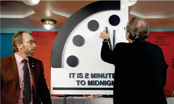  ?? Bild: CAROLYN KASTER ?? VRIDS FRAM. Fysiker Lawrence Krauss ser på när hans kollega Robert Rosner justerar domedagskl­ockan.