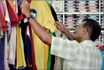  ??  ?? “Anything within my budget”: A customer looks through some T shirts. Pix by Hasitha Kulasekera