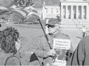  ?? AP Photos / Wilson Ring ?? Bronwyn Fryer and Rick Lawrence debate, in front of the Montpelier, Vt. statehouse, the question of Syrian refugee resettleme­nt in the U.S.