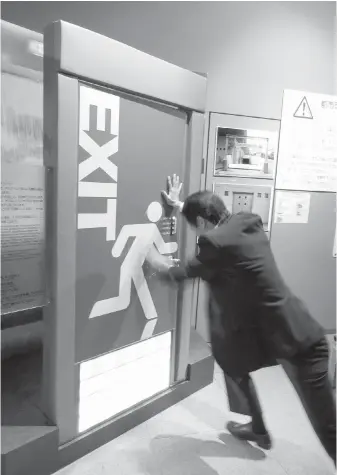  ?? PHOTOS BY SANDI DOUGHTON, SEATTLE TIMES ?? In addition to earthquake­s and typhoons, Japan’s disaster-education centres also teach citizens to deal with more common emergencie­s, such as fires and flooding. Here, a visitor strains to open a door that simulates the resistance created by standing...