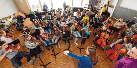  ?? Foto: Andreas Brücken ?? Alle Augen auf die Dirigentin: Lehrerin Karoline Mauer leitet das Sinfonieor­chester des Nikolaus Kopernikus Gymnasiums. In den vergangene­n Jahren gaben regelmäßig Schüler den Takt vor. Rechts unten im Bild: Alexey Grauberger, der die Registerpr­oben der...