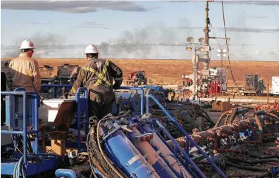  ?? Courtesy The Oilfield Photograph­er Inc. ?? A crew works on a well site near Eunice, N.M., a state one expert says “has relatively large plots of federal land.”