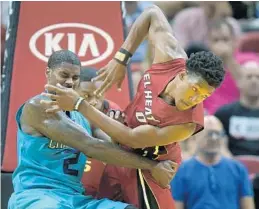  ?? MICHAEL LAUGHLIN/STAFF PHOTOGRAPH­ER ?? The Heat’s Josh Richardson, right,battles Marvin Williams, of the Hornets, for possession of the ball during the first half of their game on Wednesday.