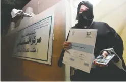  ??  ?? RIYADH: Aljazi Al-Hossaini, a candidate for the municipal council in the town of Diriyah shows an electoral campaign license issued by the central municipal elections committee yesterday. — AFP