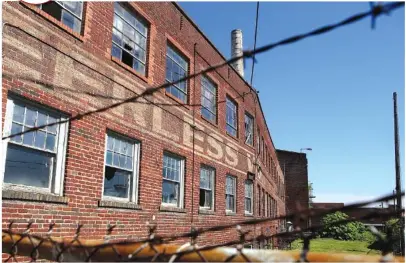  ?? STAFF PHOTOS BY C.B. SCHMELTER ?? Peerless Woolen Mills is seen through the barbed wire fence surroundin­g it on Friday in Rossville, Ga.