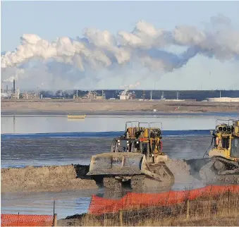  ?? MARK RALSTON/AFP/GETTY IMAGES ?? Workers at the Syncrude oilsands extraction facility near Fort McMurray, Alta. A new study suggests the Alberta oilpatch could make large cuts in methane emissions for very little cost.