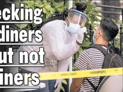  ??  ?? SAY ‘WHAA?’ A medical worker administer­s a nasal swab outside Washington Square Park on Saturday as New York City moves into Phase Four of reopening.