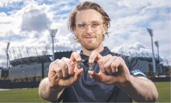  ??  ?? Collingwoo­d defender Jordan Roughead with the premiershi­p pins being launched by AFL charity Ladder. Picture: Wayne Taylor