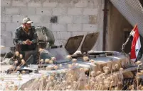  ?? (Omar Sanadiki/Reuters) ?? A SYRIAN ARMY soldier smokes a cigarette as he sits on a military vehicle in Khan Sheikhoun, Idlib, last month.