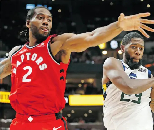  ?? RICK BOWMER / THE ASSOCIATED PRESS ?? Utah Jazz forward Royce O’Neale pulls down a rebound as Raptors forward Kawhi Leonard defends Tuesday.