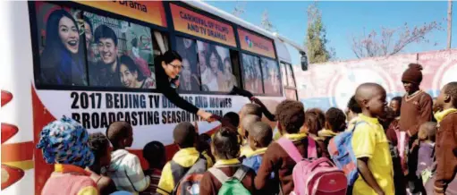  ??  ?? Staffers of the “film and television caravan” bid farewell to local children in Ethiopia. The “film and television caravan” was a major cultural activity promoted by Startimes, a Chinese media group, aiming to bring quality films and television programs to African viewers. courtesy of Startimes