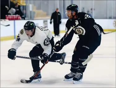  ?? NANCY LANE — BOSTON HERALD ?? Forward Georgii Merkulov, left, and defenseman Kevin Shattenkir­k battle during a training camp drill at Warrior Ice Arena.