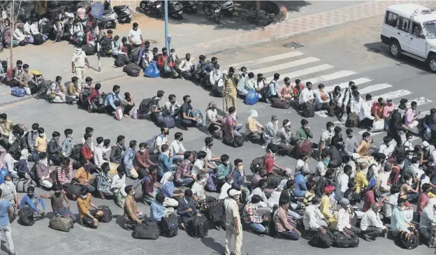  ?? PICTURE: AFP ?? 0 Stranded migrant workers queue to board buses taking them to a railway station to take trains home in Ahmedabad, India