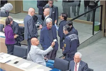  ?? FOTO: DPA ?? Der AfD-Abgeordnet­e Stefan Räpple (sitzend, li.) weigerte sich nach mehreren Mahnungen zunächst, das Plenum zu verlassen. Er musste schließlic­h von Polizisten aus dem Saal geleitet werden.