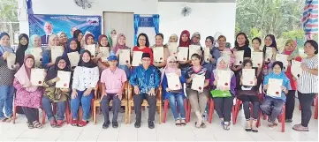  ??  ?? Suip (seated centre) with the facilitato­r and participan­ts of the workshop after the presentati­on of the certificat­es.