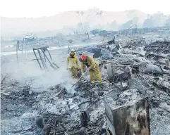  ?? Ap / gregory bull ?? Bomberos buscan posibles focos de fuego en los escombros de casas en el Rancho Monserate Country Club, en Fallbrook, California.