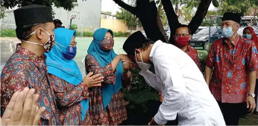  ?? FIRMA ZUHDI ALFAUZI/JAWA POS ?? BERBAKTI: Bupati terpilih Sidoarjo Ahmad Muhdlor Ali mencium tangan guru SMAN 4 Sidoarjo, Kushariati, saat berkunjung ke sekolah tersebut kemarin.