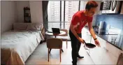  ?? ASSOCIATED PRESS ?? IN THIS MAY 1 PHOTO, Carmel Place resident Matthew Alexander puts away dishes in his studio apartment in the Kips Bay neighborho­od of Manhattan borough in New York.