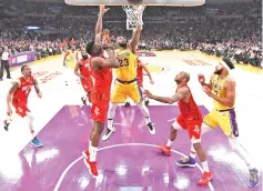  ?? — AFP photo ?? LeBron James #23 of the Los Angeles Lakers scores in front of Clint Capela #15 of the Houston Rockets as JaVale McGee #7 and PJTucker #17 look on during a 111-106 Lakers win at Staples Center in Los Angeles, California.