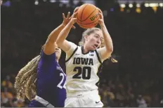  ?? MATTHEW PUTNEY/AP ?? IOWA GUARD KATE MARTIN (20) pulls down a rebound down as Holy Cross guard Simone Foreman (24) defends in the first half of a first-round game in the NCAA Tournament on Saturday in Iowa City, Iowa.