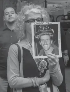  ?? BRYAN R. SMITH/THE ASSOCIATED PRESS ?? A woman holds a photograph of firefighte­r George Cain during a ceremony at the World Trade Center site in New York on Friday.