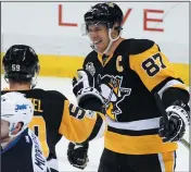  ?? AP PHOTO GENE J. PUSKAR ?? After assisting on a goal by Pittsburgh Penguins' Chris Kunitz, Sidney Crosby (87) celebrates the 1,000th point of his NHL career with Jake Guentzel (59) during the team's game against the Winnipeg Jets in Pittsburgh, Thursday.