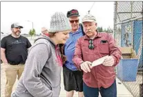  ?? CLAUDIA ELLIOTT / FOR TEHACHAPI NEWS ?? Phil Smith, far right, shares a photo with Kayla Booker, president of Tehachapi Mountain Roller Hockey. Two other members of the group who helped build Tehachapi’s roller hockey rink — Lynette and Mike Davies — were present at a recent gathering to share informatio­n about the history of the sport locally. At far left is David Shea, another member of the TMRH board working to restore the roller hockey rink in Tehachapi.