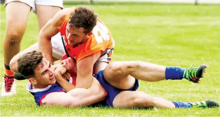  ?? Photograph­s by AMANDA EMARY. ?? Bunyip’s Matthew Sloan and Korumburra-Bena’s Jesse Harris get close and personal during a tackle.