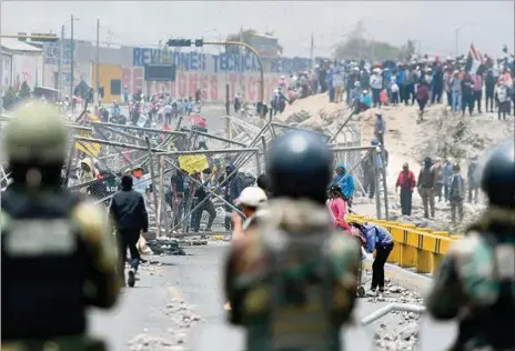  ?? ?? ENFRENTAMI­ENTO. Manifestan­tes y personal militar permanecen en el puente Añashuayco junto al aeropuerto Rodiguez Ballon en Arequipa, Perú.