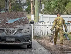  ?? AP ?? An Australian Army soldier helps with flood cleanup efforts in Gatton, Queensland. Former Defence Force chiefs say the country needs a dedicated civilian emergency response force.