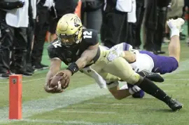  ?? Cliff Grassmick, Daily Camera ?? Colorado's Brendon Lewis reaches for and scores a touchdown against Washington on Saturday.