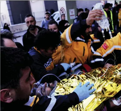  ?? IHA VIA AP ?? Rescue workers pull out Samir Muhammed Accar, a Syrian migrant, from a collapsed building in Antakya, Turkey, Saturday, Feb. 18, 2023. On the 13th day of rescue operations, three people, including a child, were extracted from under an apartment building in Antakya. The survivors, Accar, his wife and their 12-year-old son, were transferre­d to ambulances after spending 296 hours buried under the Kanatli apartment block in the center of the city, local TV reported.