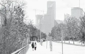  ?? Jon Shapley / Staff photograph­er ?? Two women walk along Allen Parkway during the winter storm last month. A full assessment of how big a role electric power cut to gas facilities played in the grid outages is likely months away.