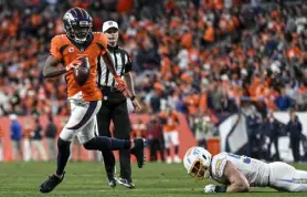  ?? Aaron Ontiveroz, The Denver Post ?? Broncos quarterbac­k Teddy Bridgewate­r evades the Chargers’ Joey Bosa moments before finding Eric Saubert in the end zone for a touchdown in the fourth quarter.