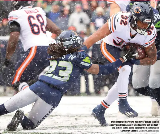  ?? ABBIE PARR/GETTY IMAGES ?? David Montgomery, who had never played in such snowy conditions, said it was tough to get his footing at first in the game against the Seahawks on Sunday in Seattle.