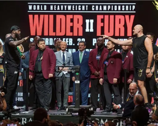  ?? Mark Ralston/Getty Images ?? Deontay Wilder, left, and Tyson Fury appear for their official weigh-in Friday at the MGM Grand Las Vegas. A skirmish between the two earlier in the week persuaded the Nevada State Athletic Commission to keep the fighters on opposite ends of the stage.
