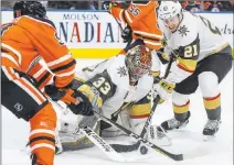  ?? Jason Franson ?? The Associated Press Knights goalie Maxime Lagace (33) stops Edmonton’s Drake Caggiula as teammate Cody Eakin (21) sweeps away the rebound.