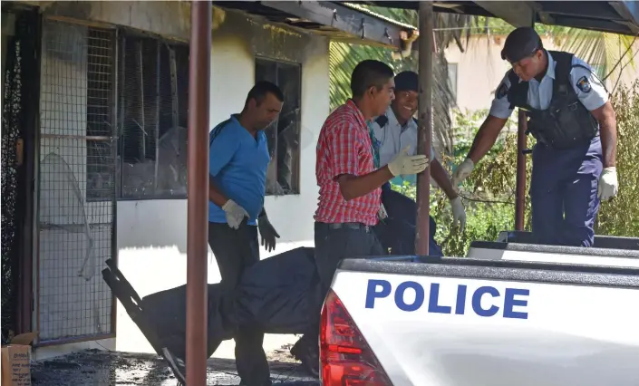  ?? Photo: Waisea Nasokia. ?? A firE At A rEsIDEnCE In NAvAkAI ClAImED tHrEE lIvEs yEstErDAy. PolICE ConfirmED tHAt tHE tHrEE DEAD wErE BEn MAtI, HEr DAuGHtEr SuryA WAtI AnD HEr DE FACto pArtnEr wHosE nAmE wAs not rElEAsED By tHE FAmIly. Pictured: PolICE oFfiCErs loAD tHE BoDy oF onE oF tHE vICtIms At NAvAkAI, NADI on MArCH 16, 2019.