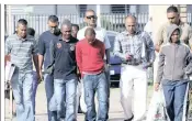  ?? PICTURE: SIYANDA MAYEZA ?? The alleged killers being led to the Durban Magistrate’s Court. In front, from left: Ally Juma Abdullah (navy shirt), Kennedy Amon Ngongi (red top) and domestic worker Nonjabulo Mteki (grey hoodie). At the back, police officers from left: Rajen Nagesur, Denver Parbhu, Lenny Naidu, Rajan Govender and Praved Maharaj.