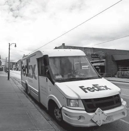  ?? JOE RONDONE/THE COMMERCIAL APPEAL ?? A Fedex truck delivers packages along South Main Street as one of the essential businesses during the coronaviru­s pandemic in March.