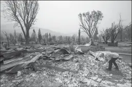  ?? MEL MELCON/LOS ANGELES TIMES ?? Amanda Peri, an inspector with Cal Fire Shasta Trinity Unit, searches through debris to determine what material the roofs of homes that burned down were made from in the town of Greenville, which was razed by the Dixie Fire, on Aug. 8.