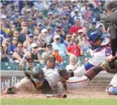  ?? GETTY IMAGES ?? The Giants’ Brandon Crawford is tagged out at home by Willson Contreras in the third inning. But the Giants crossed the plate 15 times Saturday.
