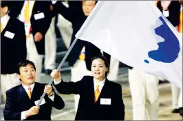  ??  ?? North Korea’s Jang Choo Pak (left) and South Korea’s EunSoon Chung carry a flag bearing the unificatio­n symbol of the Korean peninsula during the opening ceremony of the Sydney 2000 Olympic Games